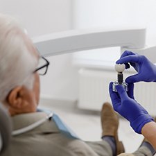 patient looking at a model of a dental implant