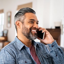 Man smiling while talking on phone