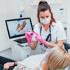 Dental assistant taking new scans of patient's teeth