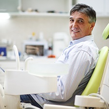 Male dental patient sitting in chair and looking to side